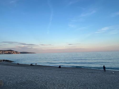 un groupe de personnes assises sur une plage près de l'océan dans l'établissement Rubis de Promenade des Anglais, à Nice