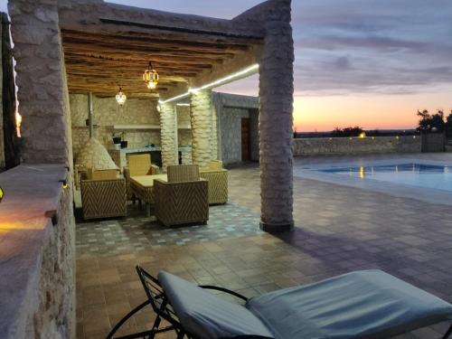 a patio with a table and chairs and a pool at Dar Éthiqua in Essaouira