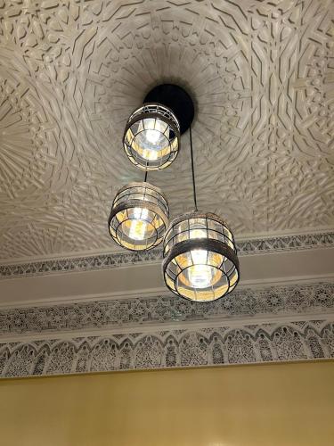 a group of lights hanging from a ceiling at Dar Éthiqua in Essaouira
