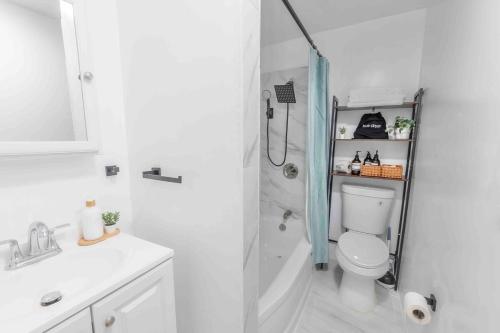une salle de bain blanche avec douche et toilettes dans l'établissement City Escape with 2 Baths, 10 beds and We Pay Half Parking for 2 cars, NYC in 15 min, à Hoboken
