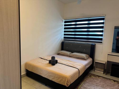 a bedroom with a bed with a black headboard and a window at Homestay Zailin A'Famosa in Kampong Pulau Sebang
