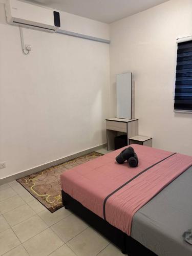 a bedroom with a bed with a teddy bear on it at Homestay Zailin A'Famosa in Kampong Pulau Sebang