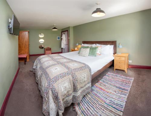 a bedroom with a large bed and a rug at Relaxing Cottage Escape - Pub - Fire - King Size Bed in Newton Aycliffe