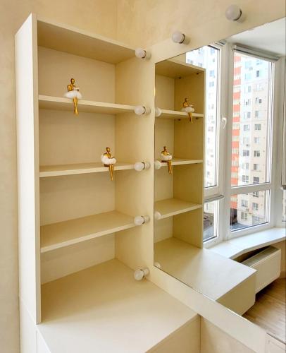 a shelf in a room with a window at Luxury design Apartment in Chişinău