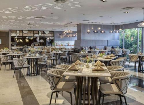 a restaurant with tables and chairs in a room at Novotel Manila Residence Hotel by Jolly Luxe Suites at Acqua in Manila