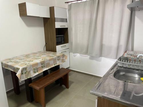 グァラトゥバにあるCasa surfのシンクとテーブルのある小さなキッチン