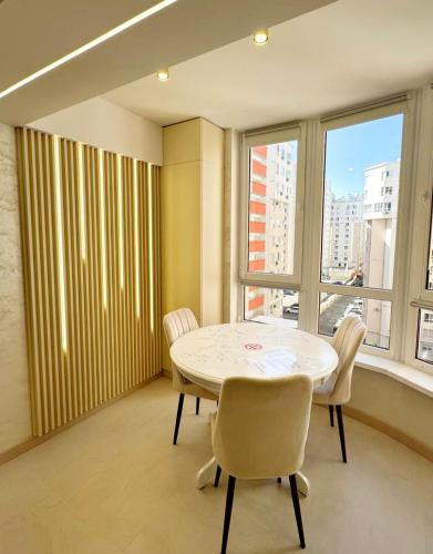 a dining room with a table and chairs and a window at Luxury design Apartment in Chişinău