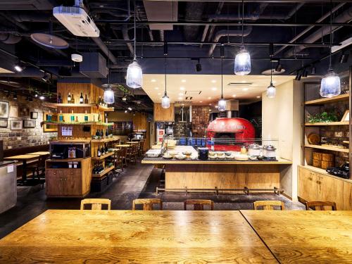 a restaurant with a large wooden table and chairs at Daiwa Roynet Hotel Kokura Ekimae in Kitakyushu