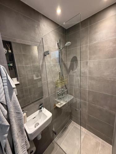 a bathroom with a sink and a glass shower at Scandic Stay CPH in Copenhagen