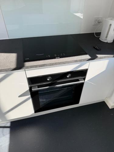 a white kitchen with a black oven in it at Scandic Stay CPH in Copenhagen