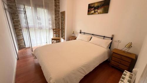 a bedroom with a white bed and a window at Twin Pines Camino Norte in Arzúa