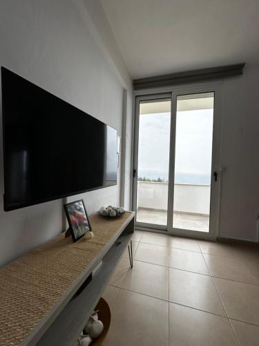 a living room with a flat screen tv on a wall at Dora's apartment in Dhërmi