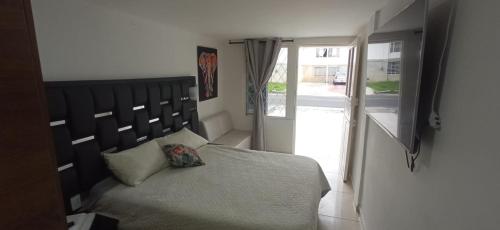 a bedroom with a bed with a large wooden headboard at TRENTO exclusivo barrio a 1 cuadra cc Campanario in Popayan