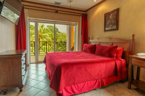 a bedroom with a red bed and a balcony at CR Luxury Veranda 7B 2 Bdrm in La Mona