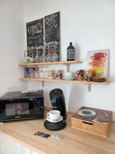 - une cuisine équipée d'un four micro-ondes et d'une cafetière sur un comptoir dans l'établissement Maison Jardin & Garage P2 10 min Gare Nîmes, à Nîmes