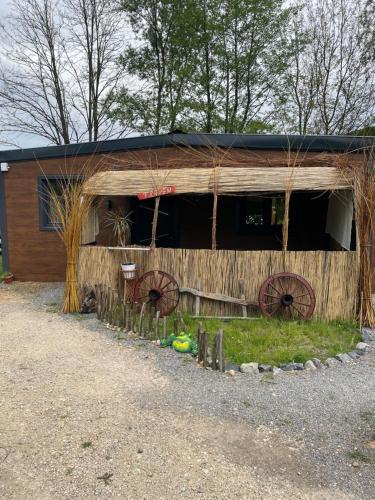 a wooden barn with two largewheels in front of it at Krupajsko vrelo in Milanovac