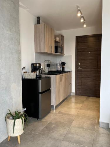 a kitchen with wooden cabinets and a black appliances at Céntrico apartamento zona 10 in Estación Pamplona