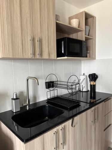a kitchen counter with a sink and a microwave at Céntrico apartamento zona 10 in Estación Pamplona