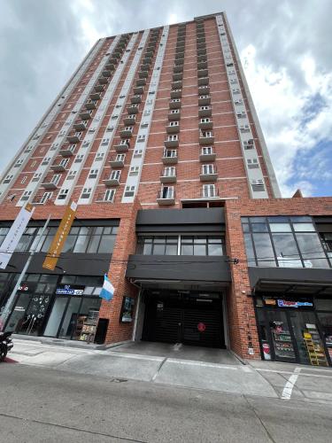 a tall red brick building with a parking garage at Céntrico apartamento zona 10 in Estación Pamplona