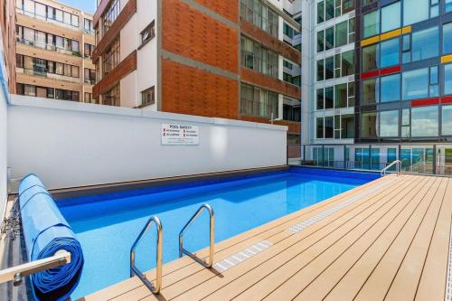 a swimming pool on the side of a building at Cityscape Retreat - Apartment with Pool and Gym in Auckland