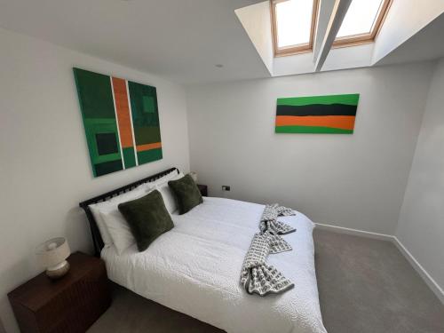 a bedroom with a white bed and some paintings at Stylish 1-Bed Central in Oxford