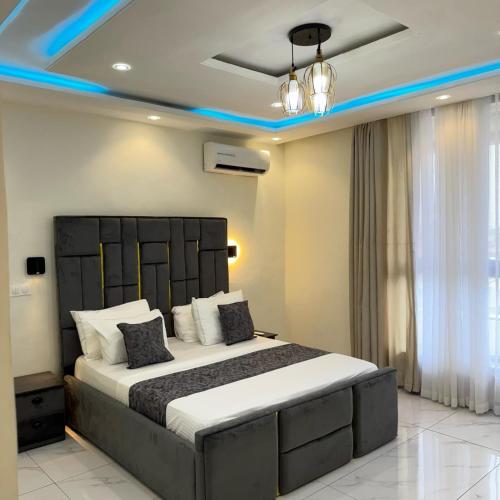 a bedroom with a large bed with blue lighting at Cité La Vie in Douala