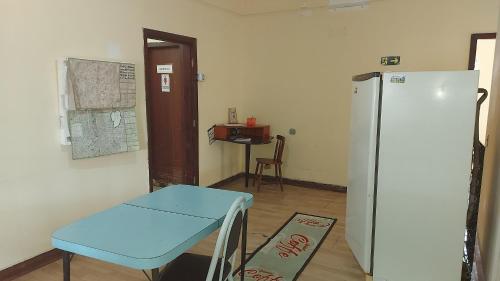 a room with a blue chair and a refrigerator at Casa de hospedes 436 in Curitiba
