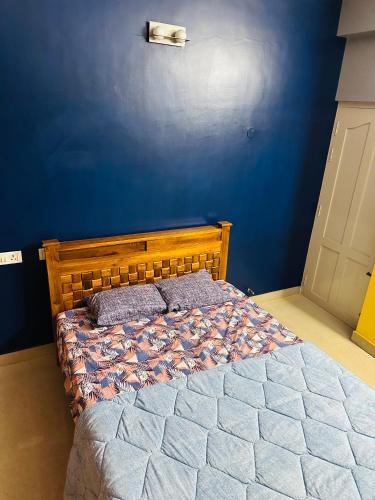 a bedroom with a wooden bed with a blue wall at Mj villa in Chennai