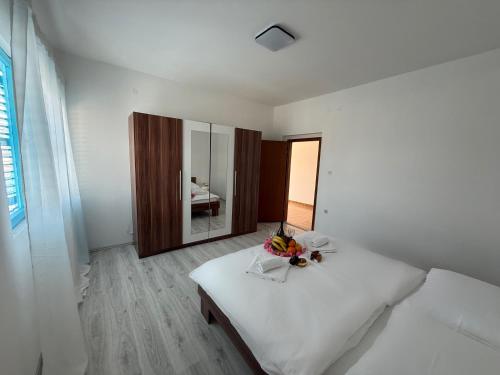 Cette chambre blanche comprend un lit et un miroir. dans l'établissement Mediterranean Blue Escape - 3BR Apartment with Balcony & Sea View, à Poljica