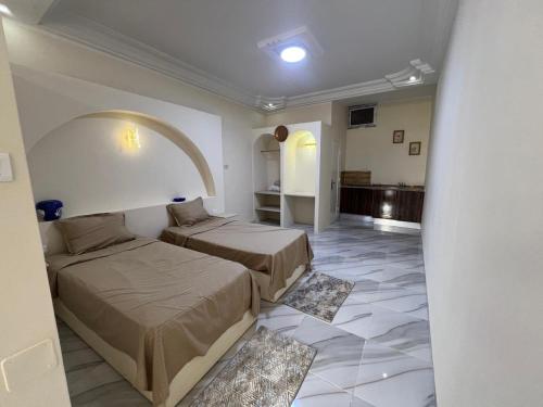 a hotel room with two beds and a hallway at Résidence Mabrouka in Qaşr Chouline