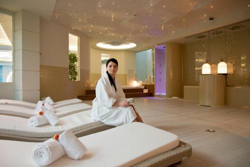 a woman in a room with four beds at Grand Hotel Da Vinci in Cesenatico