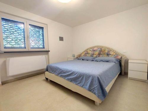 a bedroom with a bed and two windows at Villino Ambra in Marina di Pietrasanta