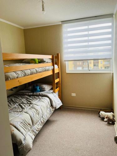 a bedroom with two bunk beds and a window at Depto amoblado 3D 2B in San Pedro de la Paz