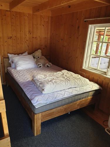 two teddy bears sitting on a bed in a cabin at Holiday Raustua Cabin in Gol