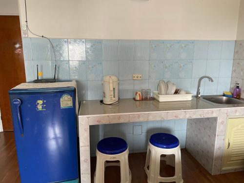 a small kitchen with a sink and stools in it at Dailyroom C3,C4by Anna in Nonthaburi