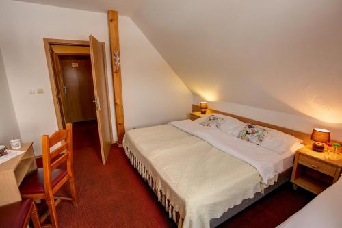 a bedroom with a bed and a table and a chair at Hotel Koliba Greta in Liptovská Sielnica