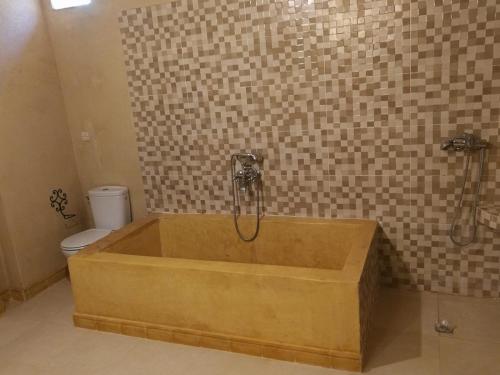 a bath tub in a bathroom with a toilet at Chez Kossai Atlas Farm in Chtawna