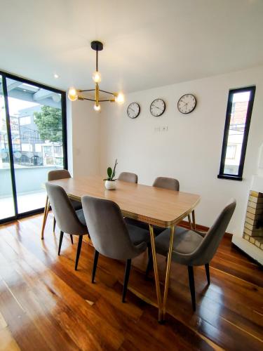 a dining room table with chairs and clocks on the wall at Eurolan 72 in Bogotá