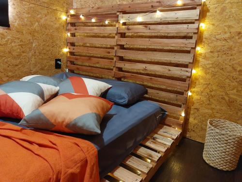 a bedroom with a bed and a wooden wall at Casa Container in Águas de Lindoia