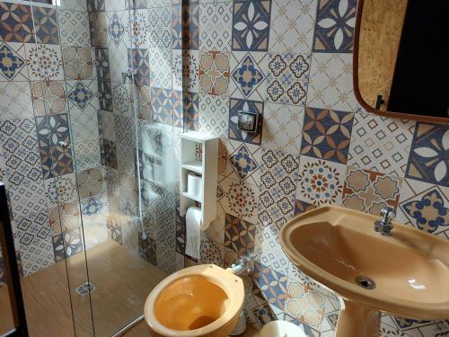 a bathroom with a toilet and a sink at Casa Container in Águas de Lindóia