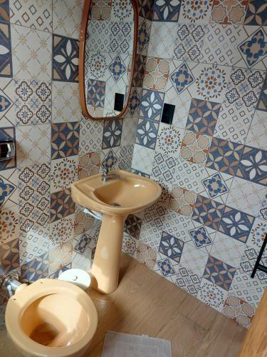 a bathroom with a toilet and a sink at Casa Container in Águas de Lindoia