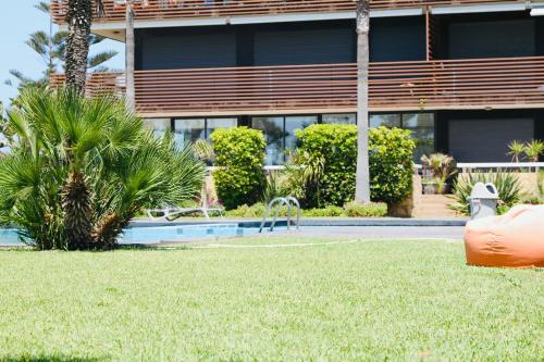 a building with a swimming pool in front of a yard at Prestige apartment, Tamaris, sea view in Tamaris