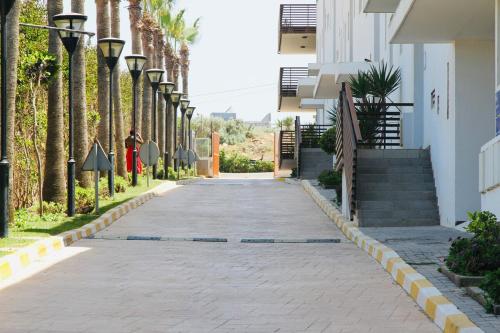 an empty street with palm trees on the side of a building at Prestige apartment, Tamaris, sea view in Tamaris