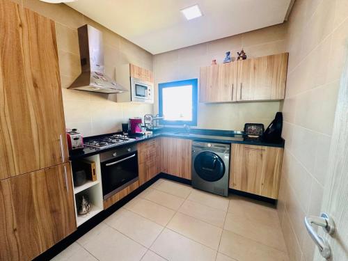 a small kitchen with a stove and a dishwasher at Prestige apartment, Tamaris, sea view in Tamaris