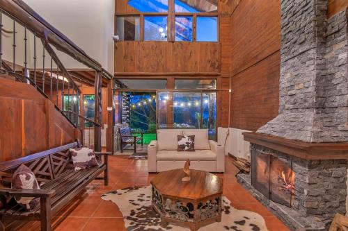 a living room with a stone fireplace in a house at Cabin in the Clouds in Tapantí