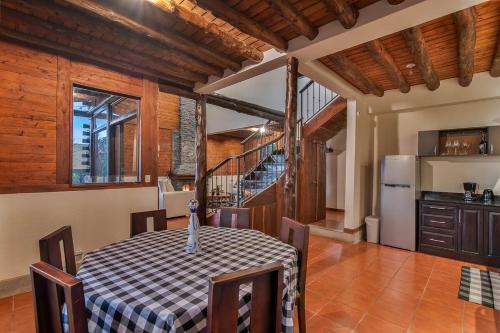 a kitchen and dining room with a table and a refrigerator at Cabin in the Clouds in Tapantí