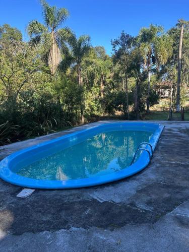 a blue swimming pool in a parking lot at Recanto Amado in Araucária