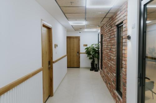 a corridor of an office with a brick wall at Goland Hotel in Mas'ade