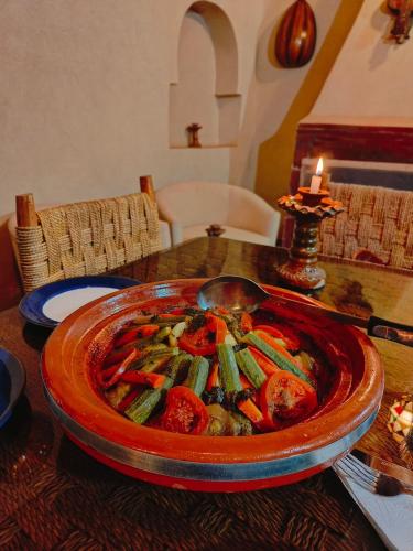 a table with a bowl of food on a table at Chez Kossai Atlas Farm in Chtawna