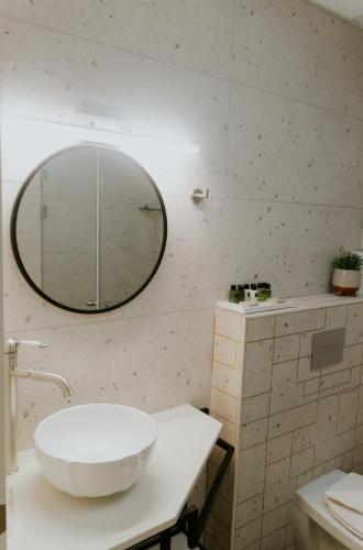 a bathroom with a sink and a mirror on the wall at Goland Hotel in Mas'ade